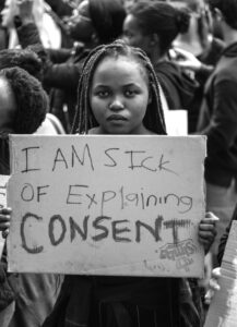 Port Elizabeth, South Africa - September 2019: A young black woman holding a sign that says "I am sick of explaining consent" at a protest against gender-based violence in South Africa