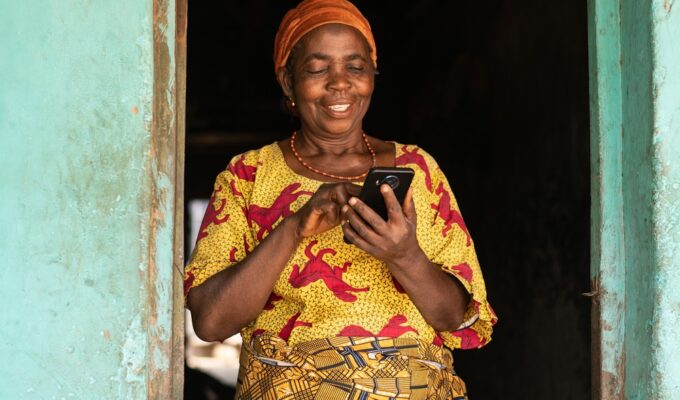 African woman using a phone smiling