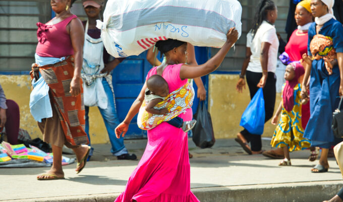 A woman carrying luggage and a child in Accra Ghana