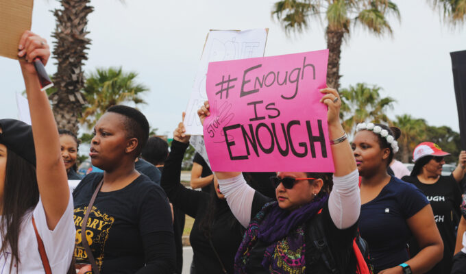 Port Elizabeth, South Africa - September 2019: A protester holding a sign that says "enough is enough" at a protest to remember women who were raped and killed in South Africa.