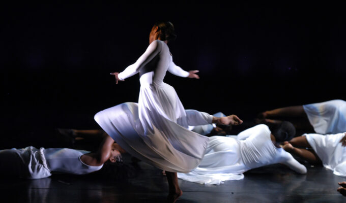 a dancer on stage in long white dress