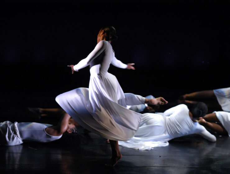a dancer on stage in long white dress